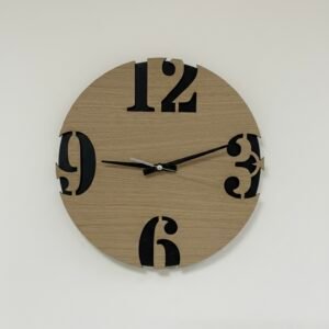 Modernus sieninis laikrodis su kontrastingais skaičiais, pagamintas Lietuvoje. Laikrodis šviesios medžio spalvos su juodomis rodyklėmis ir išpjautais juodais skaičiais. Stilingas, minimalistinio stiliaus.